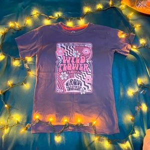 tee shirt that says “kindness blooms here wild flower festival grow together”